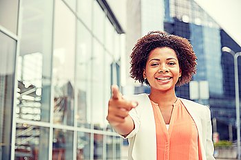 business, gesture and people concept - young smiling african american businesswoman in city pointing finger on you