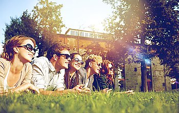 summer holidays, friendship, leisure and teenage concept - group of students or teenagers hanging out at campus or park