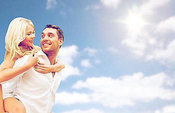 people, summer holidays, vacation and love concept - happy couple having fun over blue sky and clouds background