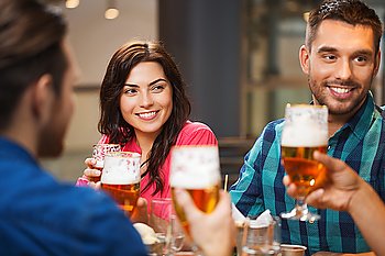 leisure, eating, food and drinks, people and holidays concept - smiling friends having dinner and drinking beer at restaurant or pub