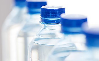 recycling, healthy eating, industry, packing and food storage concept - close up of plastic bottles with pure drinking water