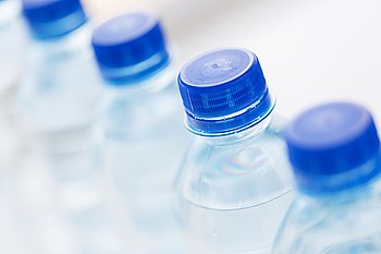 recycling, healthy eating, industry, packing and food storage concept - close up of plastic bottles with pure drinking water