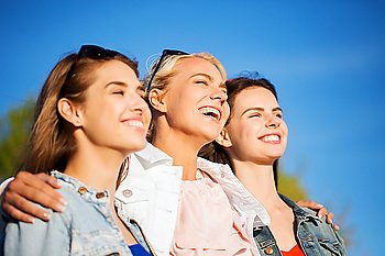 summer vacation, holidays, friendship and people concept - group of happy smiling young women or teenage girls hugging outdoors