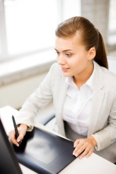 picture of smiling businesswoman with drawing tablet in office