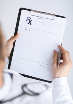 close up of male doctor writing prescription paper