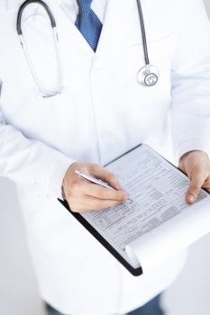 close up of male doctor holding prescription paper in hand