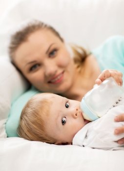 happy mother and adorable baby with feeding-bottle