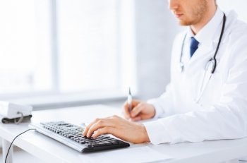 close up of male doctor typing  on the keyboard