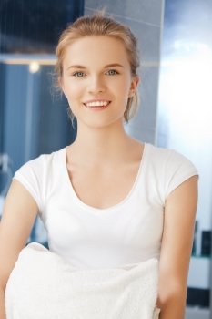 picture of smiling teenage girl with towels in bathroom