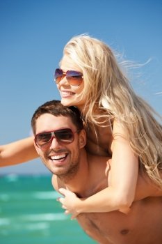 picture of happy couple in sunglasses on the beach (focus on man)