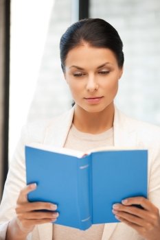 bright picture of calm and serious woman with book