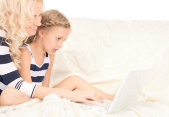 bright picture of happy mother and child with laptop computer
