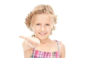 little girl holding something on the palm of her hand
