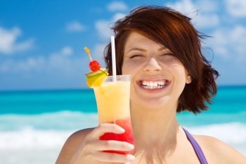 happy woman with colorful cocktail on the beach