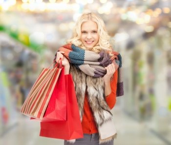 sale, shopping and mall concept - smiling teenage girl with shopping bags at shopping mall