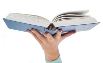 education and book concept - close up of woman hand holding open blue book