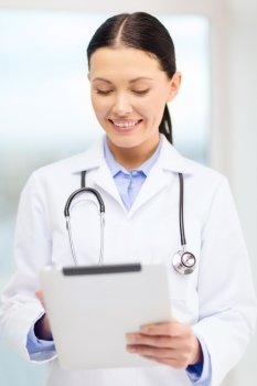 healthcare, technology and medicine concept - smiling young doctor with tablet pc computer and sthethoscope in cabinet