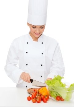 cooking and food concept - smiling female chef chopping vegetables