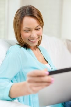 technology, internet and home concept - woman with tablet pc computer at home