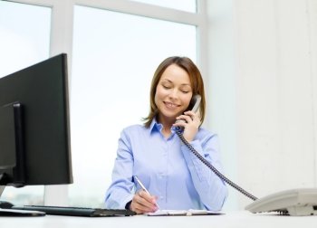 business, communication and education concept - smiling businesswoman with laptop, documents and telephone