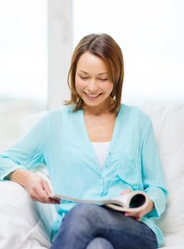 home and leasure concept - smiling woman reading magazine at home