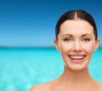 health, spa and beauty concept - clean face of beautiful young laughing woman
