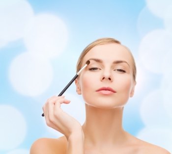 cosmetics, health and beauty concept - beautiful woman with makeup brush