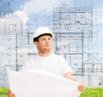 building, developing, construction and architecture concept - male architect in helmet looking at blueprint