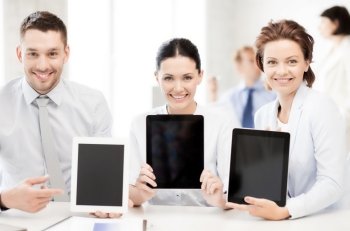 smiling business team showing tablet pcs in office