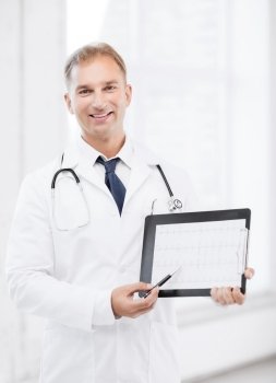 healthcare and medical concept - male doctor with stethoscope showing cardiogram