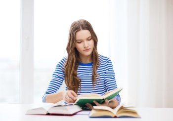 education and home concept - concecntrated student girl with books