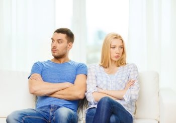 love, family and happiness concept - unhappy couple not speaking after having argument at home