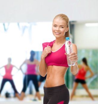 fitness, healthcare and dieting concept - smiling sporty woman with bottle of water and towel