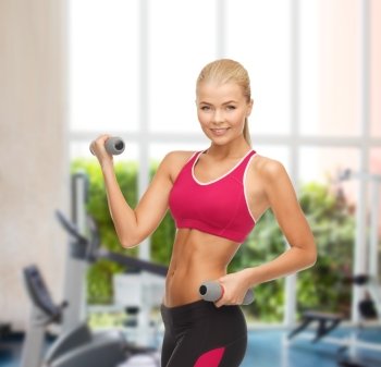 fitness and gym concept - young sporty woman with light dumbbells