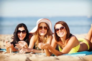 summer holidays and vacation - girls sunbathing on the beach