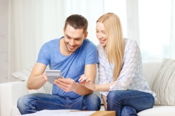 tax, finances, family, home and happiness concept - smiling couple with papers and calculator at home