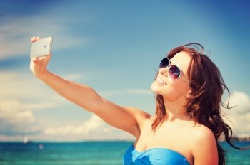 picture of happy woman with phone on the beach