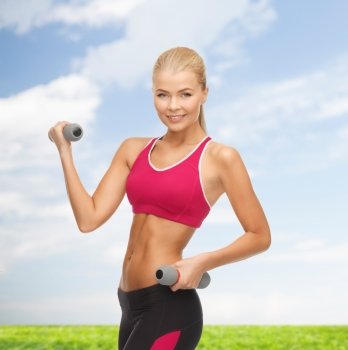 fitness and healthcare concept - young sporty woman with light dumbbells