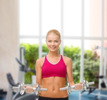 fitness, healthcare and dieting concpt - young sporty woman with heavy steel dumbbells