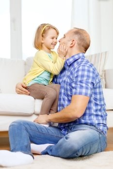 family, child and happiness concept - smiling father and daughter playing at home