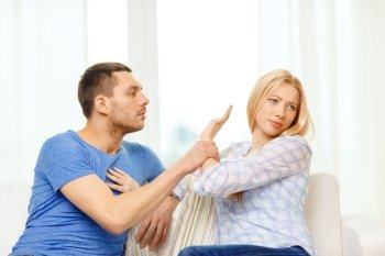 love, family and happiness concept - unhappy couple having argument at home