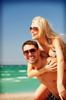 picture of happy couple in sunglasses on the beach (focus on man)