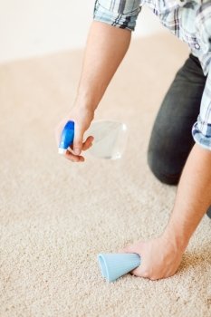 cleaning and home concept - close up of male cleaning stain on carpet with cloth