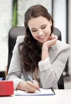 happy woman with documents writing something down