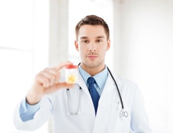 picture of young male doctor with jar of capsules