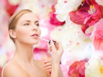cosmetics, health and beauty concept - beautiful woman with pink lipgloss