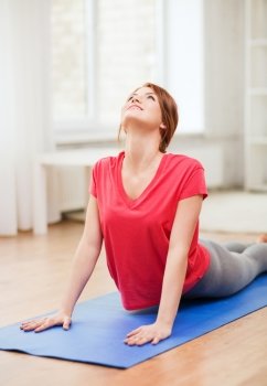 fitness, home and diet concept - smiling teenage girl streching at home