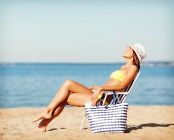 summer holidays and vacation - girl in bikini sunbathing on the beach chair
