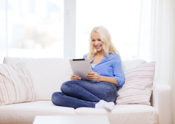 business, technology and e-learning concept - smiling woman with tablet pc computer at home