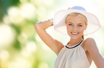 fashion, happiness and lifestyle concept - beautiful woman in hat enjoying summer outdoors